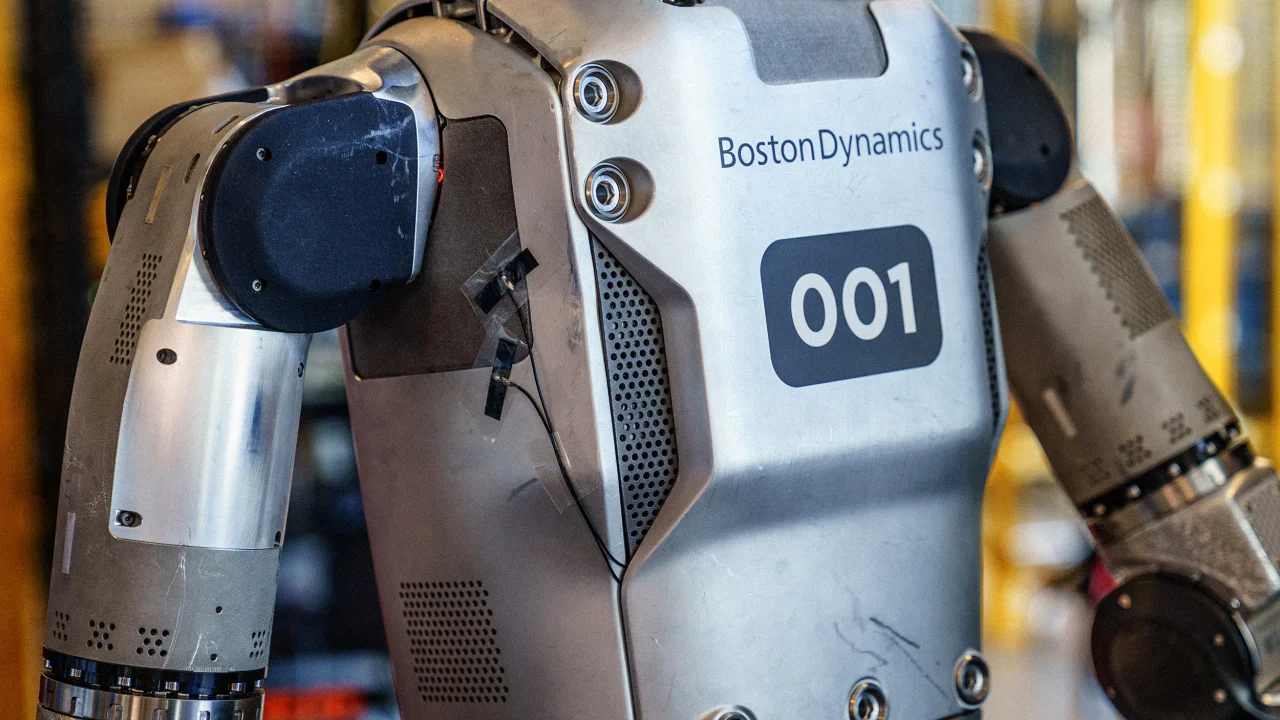 Closeup of chest and arms of robot with Boston Dynamics written above the number 001.