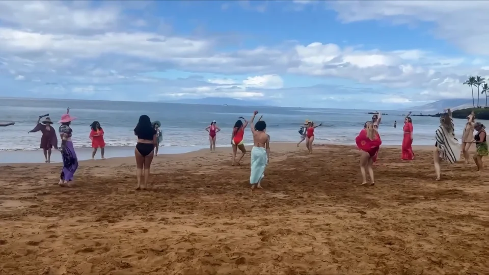 BeachDance participants move with wireless headphones beside the ocean on Maui.