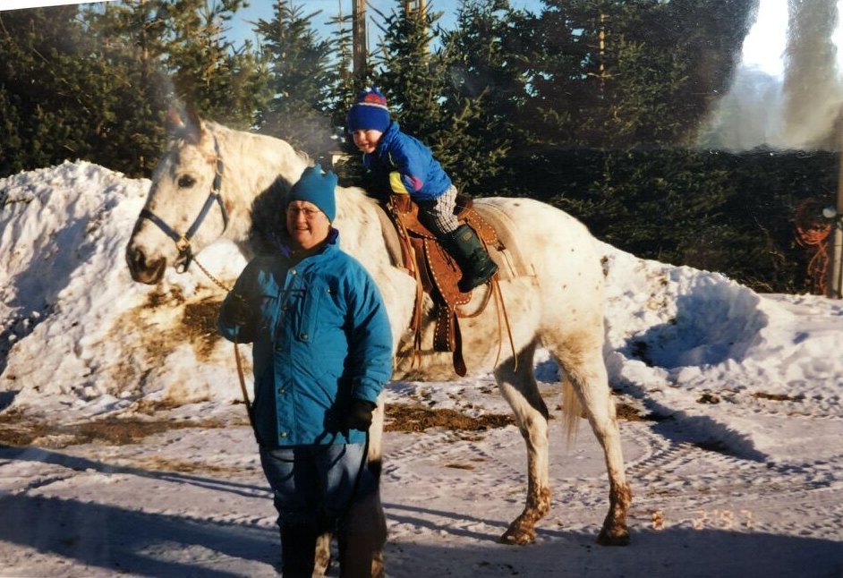Alec as a small boy on a white horse in the snow