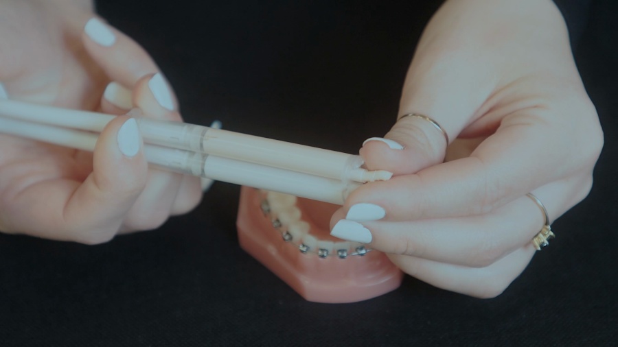 <p>Dr. Jeff provides instructions for maintaining dental hygiene at school during lunch breaks. He demonstrates how to use a portable dental care kit that includes a travel toothbrush, floss pick, proxy brush, and orthodontic wax. The video shows proper techniques for applying orthodontic wax to areas that may be causing discomfort, including how to roll it into a ball and press it onto problem areas.</p>
