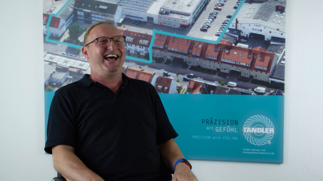 Still from the Tandler film: an employee laughing during his interview