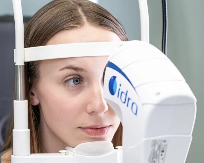 Patient positioned at the IDRA chin rest for a tear film exam
